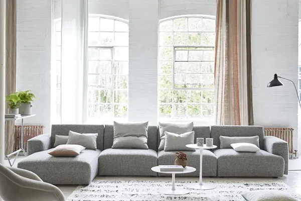 Un espacioso sofá modular gris en una habitación luminosa - SUNSGOODS - SUNSGOODS Un espacioso sofá modular gris en una habitación luminosa.