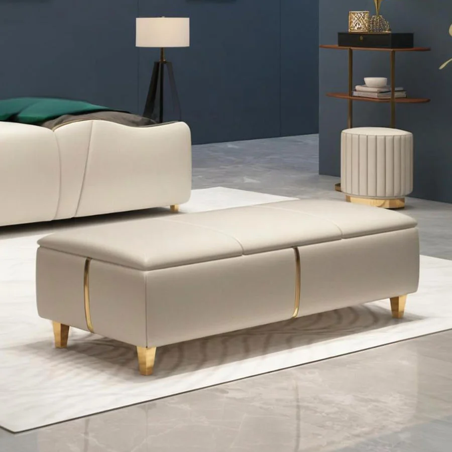 Elegante banco de almacenamiento de cuero con detalles dorados.