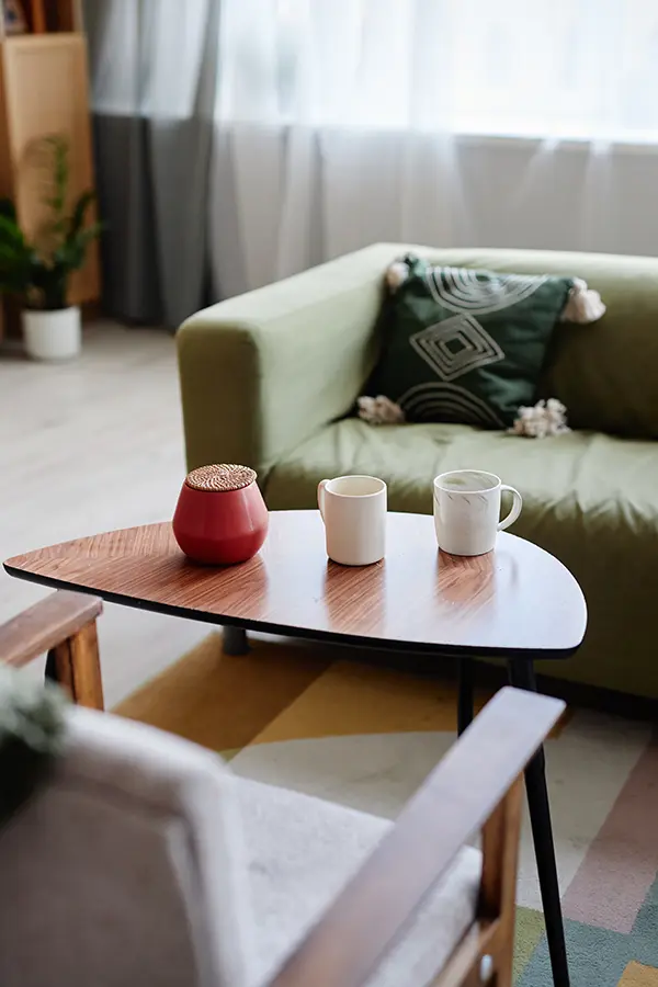 Mesita de centro pequeña de madera con tazas de cerámica.