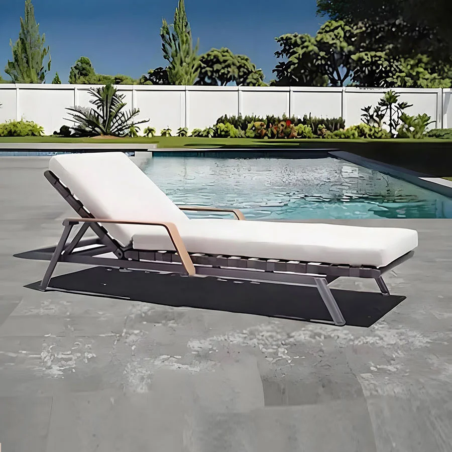Tumbona minimalista de exterior junto a la piscina.