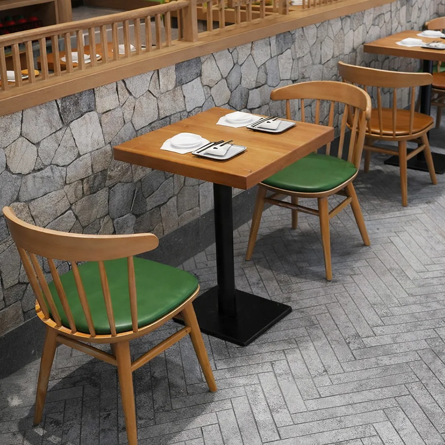Mesa de comedor de madera con cómodas sillas verdes.